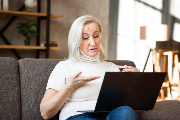 Donna del colpo medio con il computer portatile