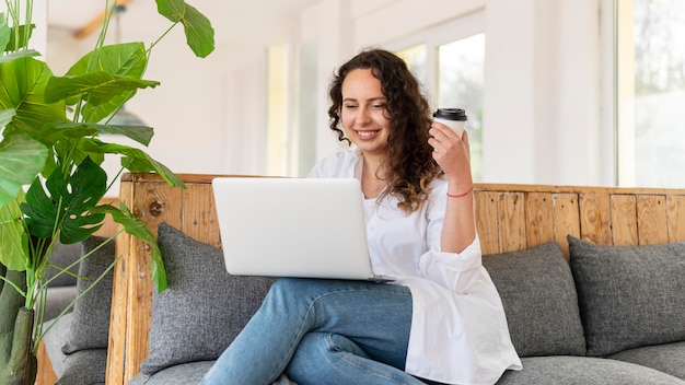 Donna del colpo medio con il computer portatile