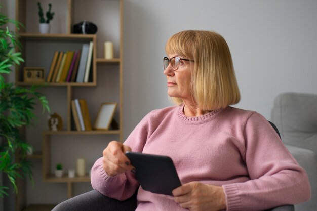 Donna del colpo medio con il lettore del libro elettronico