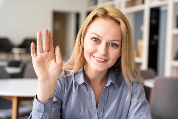 Donna del colpo medio con la mano in su