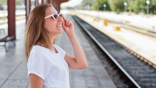 Donna del colpo metà sorridente nella stazione ferroviaria