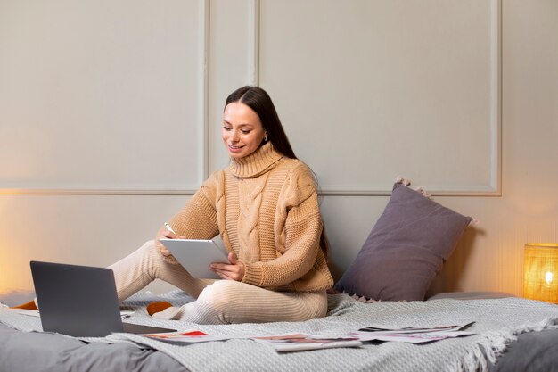 Donna del colpo pieno che assorbe l'ipad