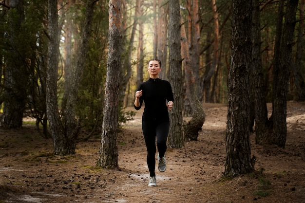 Donna del colpo pieno che corre nella natura