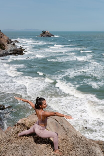 Donna del colpo pieno che fa yoga in natura