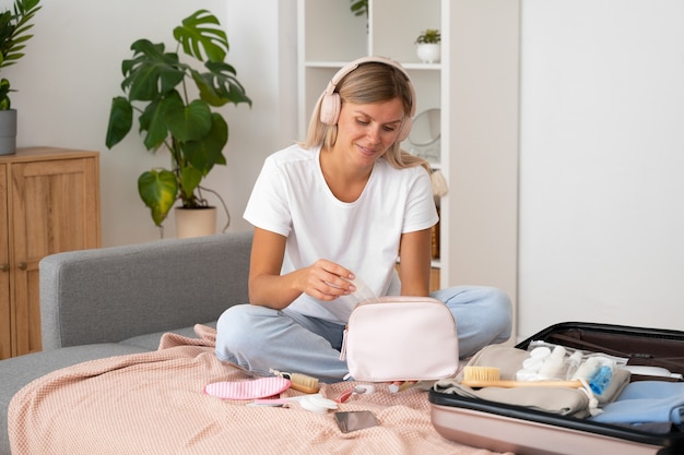 Donna del colpo pieno che imballa piccola borsa