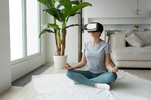 Donna del colpo pieno che medita con gli occhiali del vr