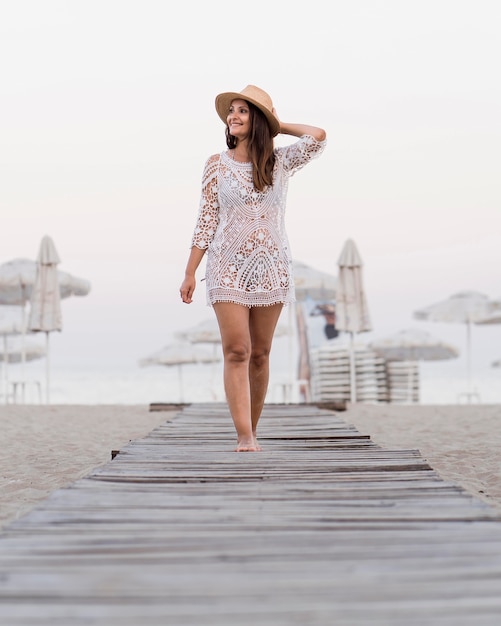 Donna del colpo pieno che posa alla spiaggia