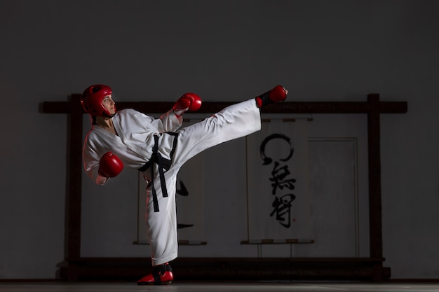 Donna del colpo pieno che pratica taekwondo