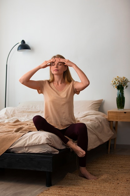 Donna del colpo pieno che pratica yoga facciale