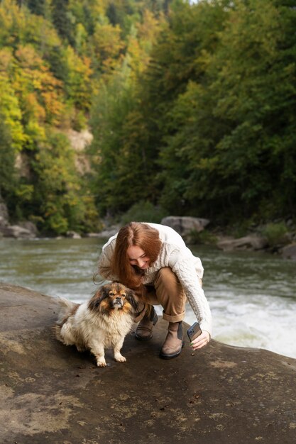 Donna del colpo pieno che prende selfie con il cane