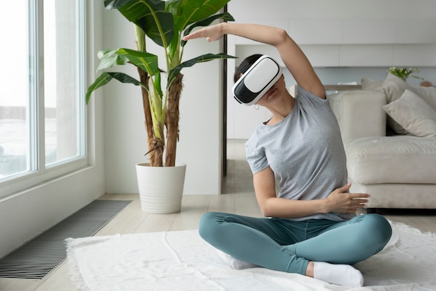 Donna del colpo pieno che si esercita con gli occhiali del vr