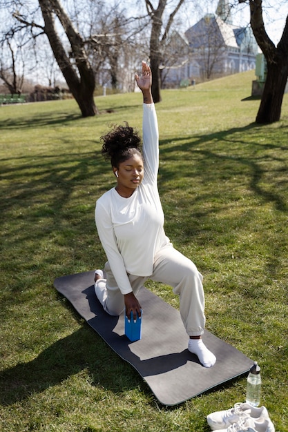 Donna del colpo pieno che si esercita con il blocco di yoga