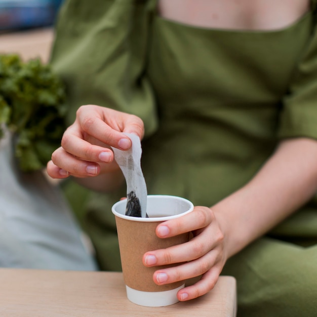 Donna del primo piano che cattura bustina di tè dalla tazza