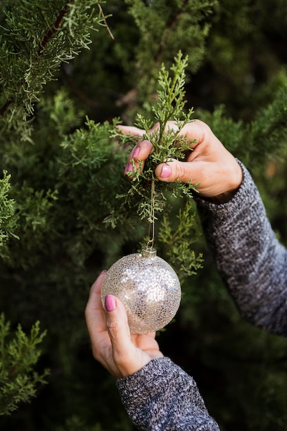 Donna del primo piano che decora l'albero di Natale