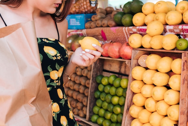 Donna del primo piano che esamina i limoni