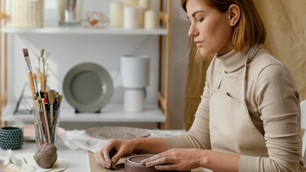 Donna del primo piano che fa ceramiche a casa