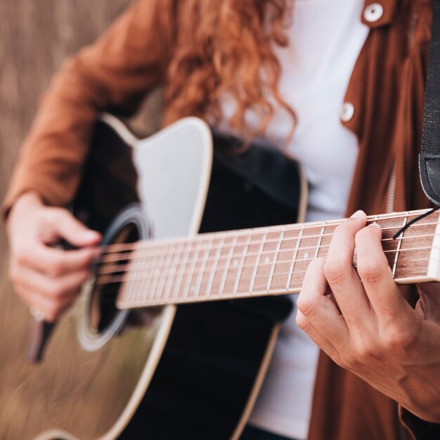 Donna del primo piano che gioca chitarra