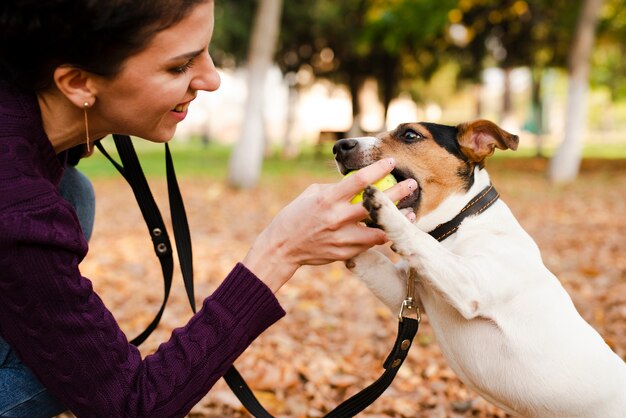 Donna del primo piano che gioca con il suo cane