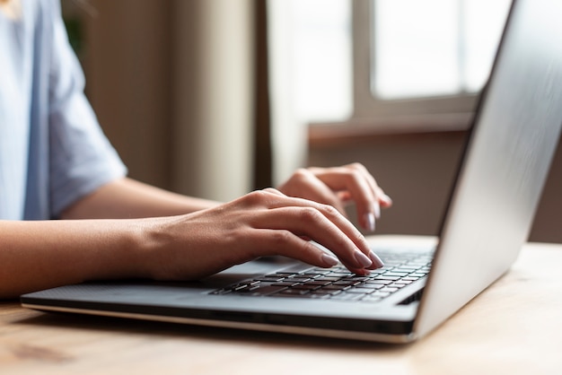 Donna del primo piano che lavora ad un computer portatile