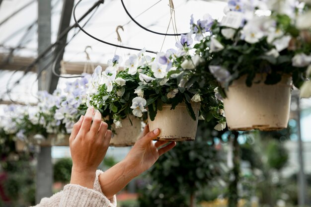 Donna del primo piano che organizza i vasi da fiori