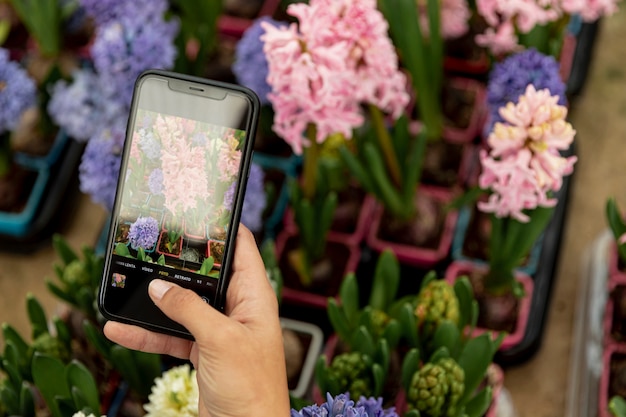 Donna del primo piano che prende una foto dei fiori