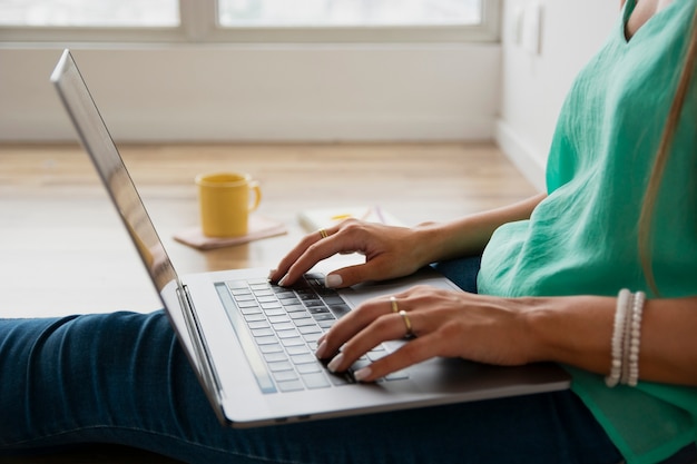 Donna del primo piano che si siede sul pavimento e sul lavoro