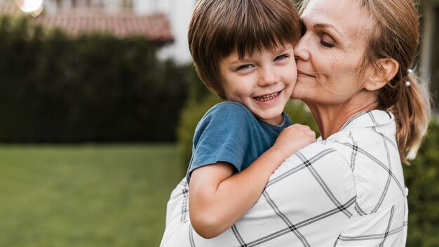 Donna del primo piano che tiene bambino felice