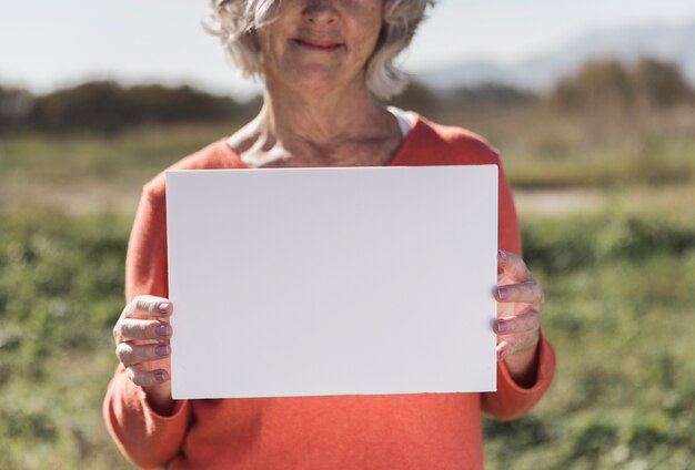 Donna del primo piano che tiene un pezzo di carta