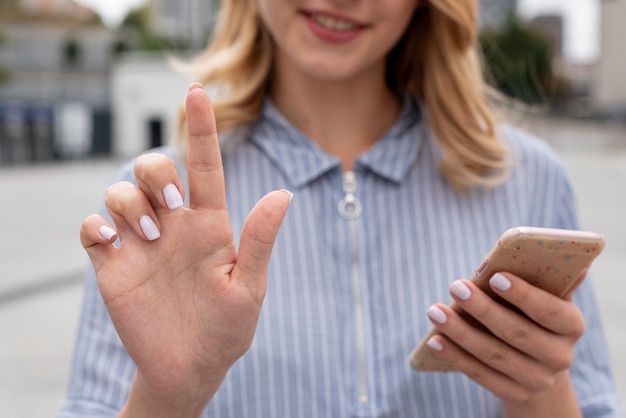 Donna del primo piano che tiene uno smartphone