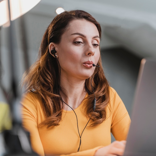 Donna del primo piano in streaming con il computer portatile