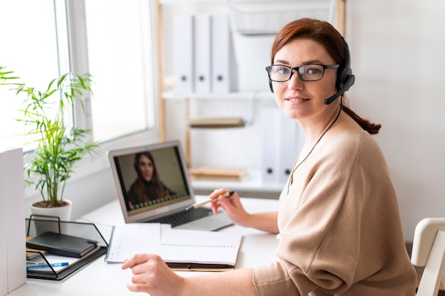 Donna del ritratto al lavoro che ha videochiamata sul laptop