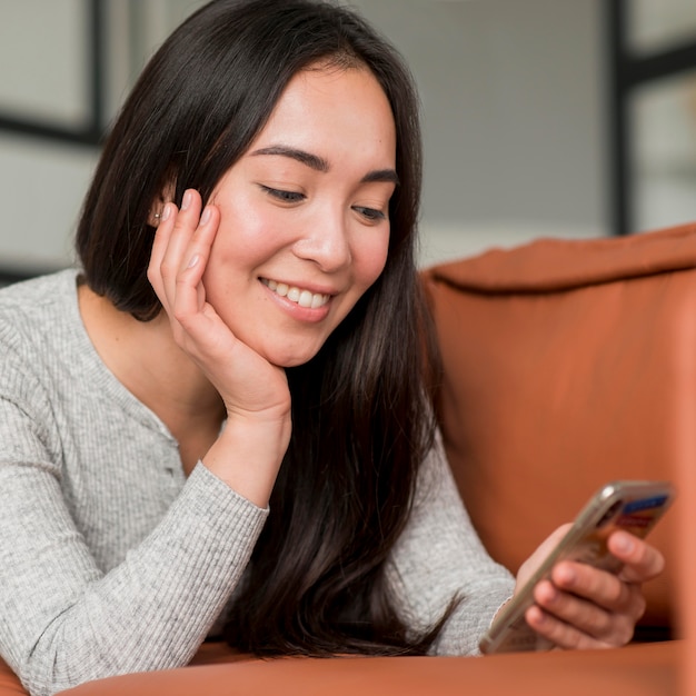 Donna del ritratto che per mezzo del telefono