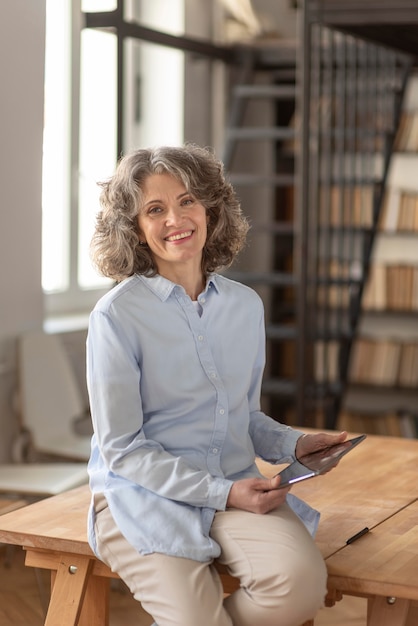 Donna del ritratto con la camicia convenzionale facendo uso della compressa