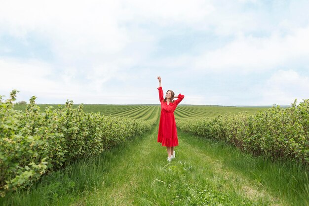 Donna del ritratto in vestito rosso nel campo