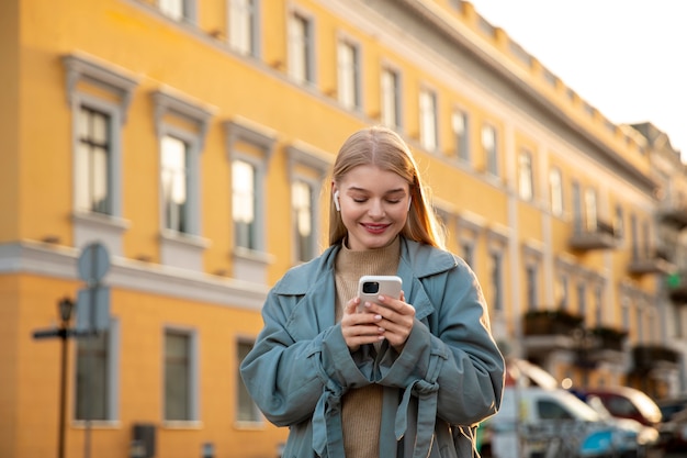 Donna del tiro medio che digita sul telefono