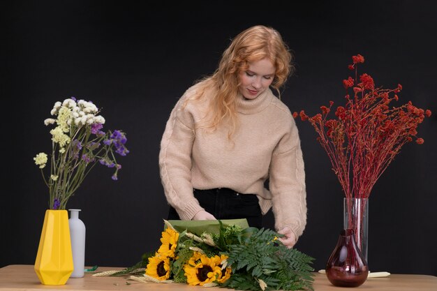 Donna del tiro medio che fa il mazzo di fiori