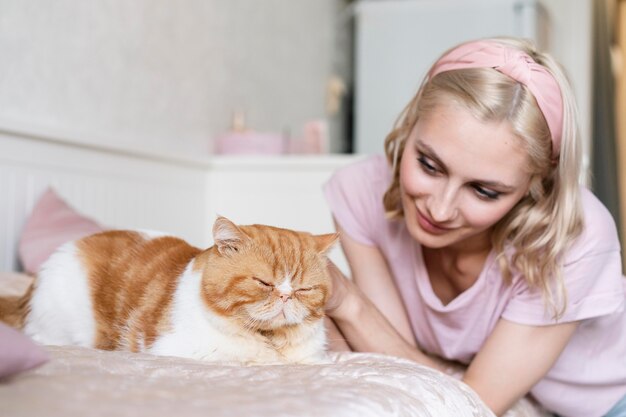 Donna del tiro medio che guarda il gatto