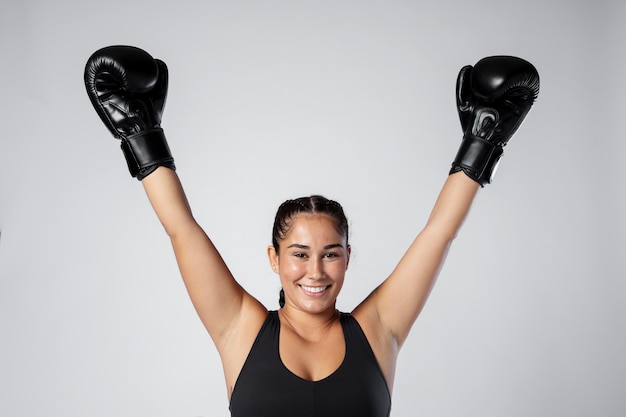 Donna del tiro medio che indossa guanti da boxe