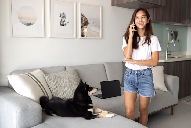 Donna del tiro medio che parla al telefono a casa