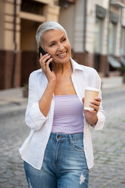 Donna del tiro medio che parla al telefono