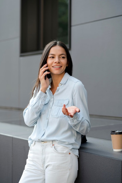 Donna del tiro medio che parla al telefono