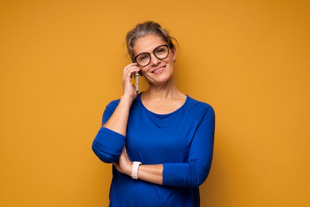 Donna del tiro medio che parla al telefono