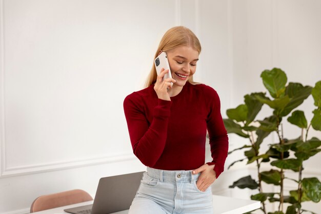 Donna del tiro medio che parla al telefono