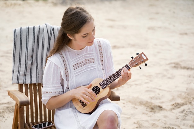 Donna del tiro medio che suona l'ukulele