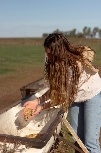 Donna del tiro medio che tiene cibo per animali