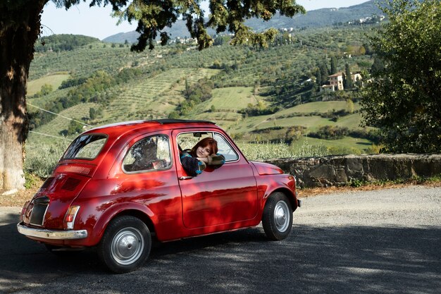 Donna del tiro medio in macchina rossa