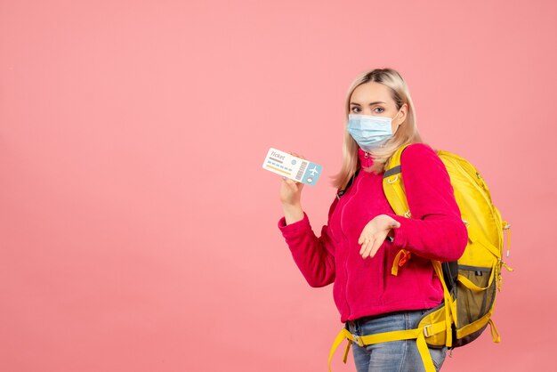 Donna del viaggiatore di vista frontale con il biglietto della holding della maschera