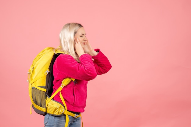 Donna del viaggiatore di vista frontale con lo zaino che chiude le orecchie con le mani