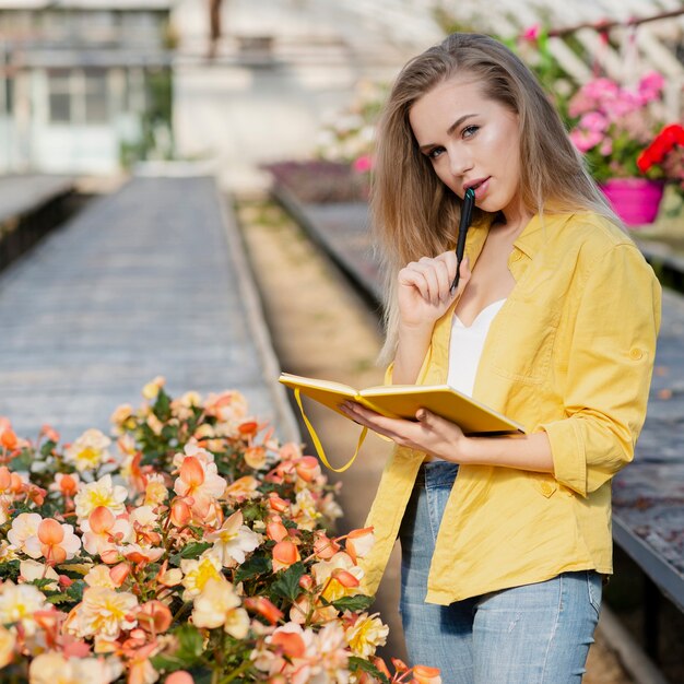 Donna dell'angolo alto che controlla agenda per i fiori