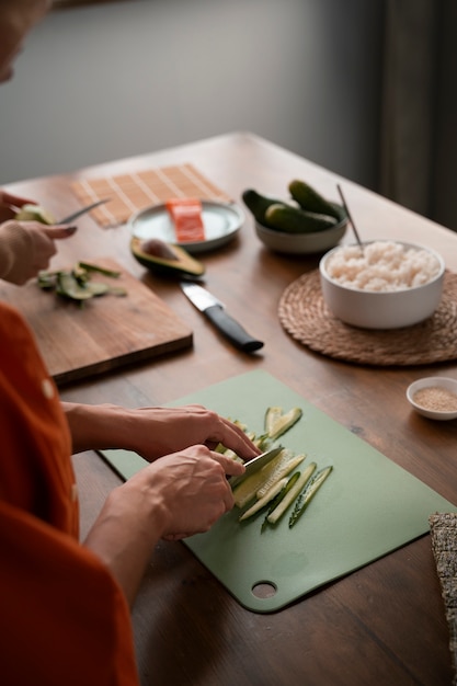 Donna dell'angolo alto che impara a fare i sushi